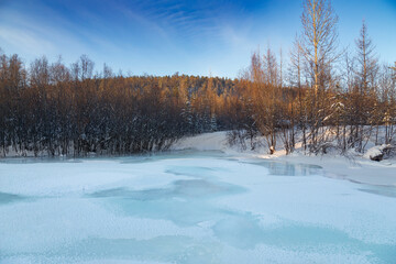Ice on a small river. Evening winter landscape
