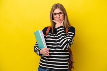 Young student woman isolated on yellow background background thinking