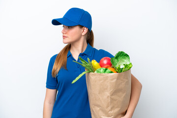 Young delivery woman taking a bag of takeaway food isolated on white background looking to the side