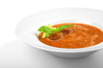 Close-up of tasty tomato soup in white plate isolated on white background