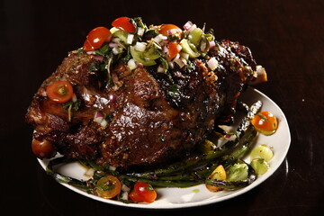 Whole roasted lamb leg with mint sauce and vegetables