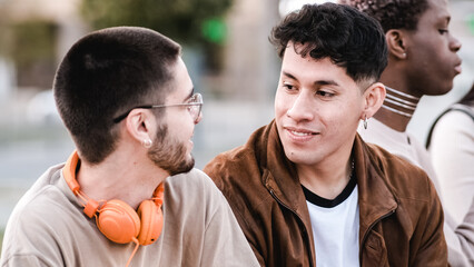 Two friends taking and joking while sitting outdoors