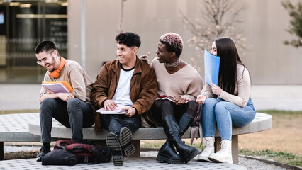 Multicultural group of friends enjoying while chatting together in the university