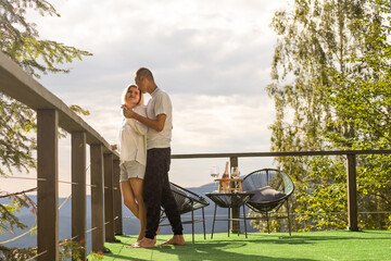 Couple on the balcony against the backdrop of mountains. life terrace pretty happiness summer home.