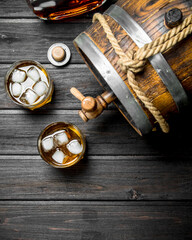 Whisky in glasses and barrel.