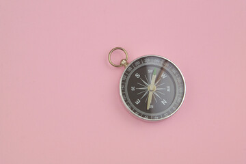 Compass on pink background with copy space for text. Tourism and navigation concept.