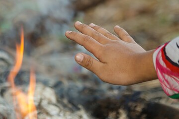 Children's hands warming the fire in winter