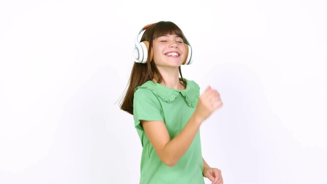Little girl listening to music with headphones over isolated background