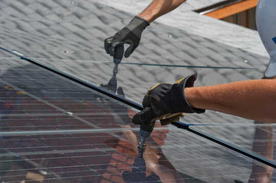 Solar installers work together on frameless installation.