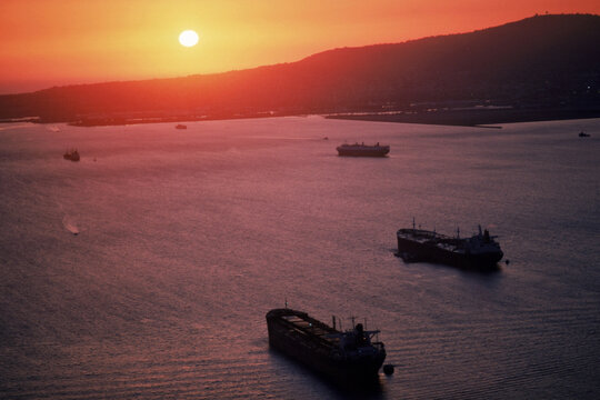 Freighters sailing into a sunset.