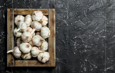 Garlic in wooden tray.