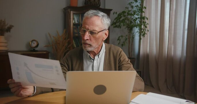 Mature man analyses statistics and works on project