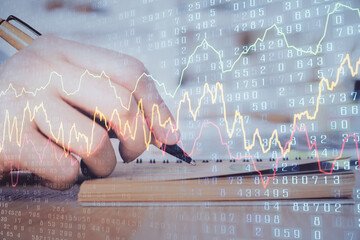 Double exposure of man doing notes of stock market with forex graph.