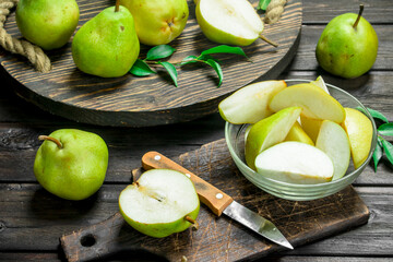 Fototapeta na wymiar Pieces of fresh pear in a bowl on a cutting Board with a knife.