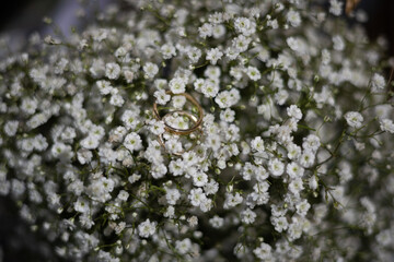 Wedding rings placed on a bouquet of white flowers