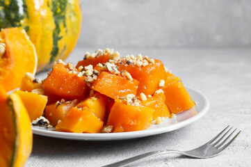 Traditional Turkish Pumpkin Dessert with sherbet on rustic table and fresh sliced pumpkins