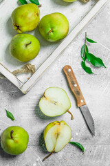 Ripe pear in the tray with a knife.
