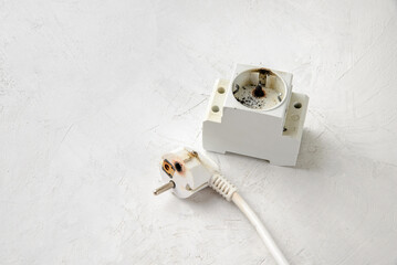 Electrical short circuit. Burnout of the din socket and plug. Gray concrete background, close-up, space for text.
