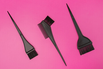 hair coloring tools, hairdresser's brushes on a pink background