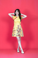 A beautiful asian woman doing a pose while wearing simple yellow chinese dress