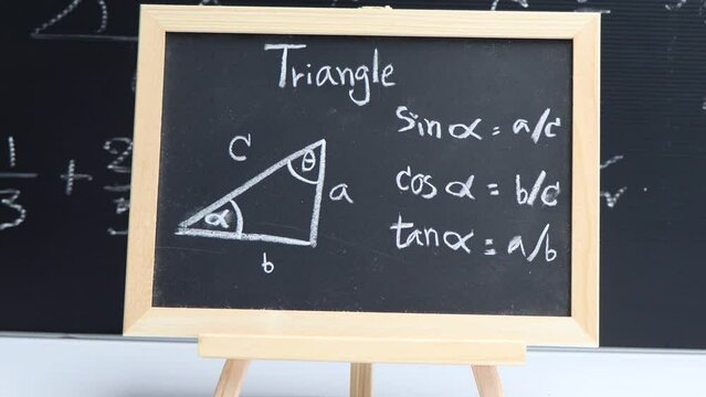 Blackboard with hand written geometry volume formulas and geometric shapes