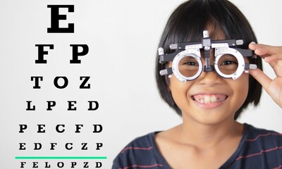 Elementary school girl wearing eyeglasses visual acuity test with test chart, eye test