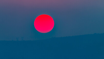 Sun Red Planet Setting or Rising over the Countryside Distant Landscape.