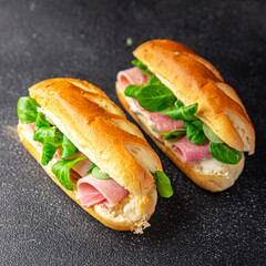 sandwich ham french milk bun, cheese, lettuce green leaves bio product fresh healthy meal food snack on the table copy space food background rustic top view