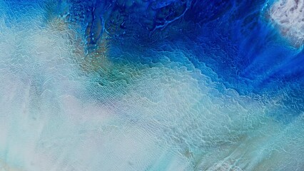 Abstract background with effect sea waves and foam. Smartphone wallpaper or theme. Fluid art of movement with blue and white colors. Artistic video painted with liquid acrylic paints.