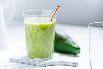 Green smoothie made from avocado and chia seeds on white background. Healthy living lifestyle. 