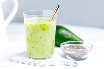 Green smoothie made from avocado and chia seeds on white background. Healthy living lifestyle. 