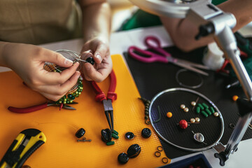 Close up photo designer making handmade jewelry in studio workshop. Fashion, creativity and handmade concept.