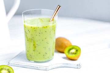 Green smoothie in glass served with straw. Made from kiwi and chia seeds. Super food and antioxidant for healthy lifestyle