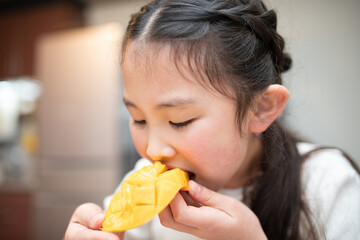 マンゴーを食べる子供