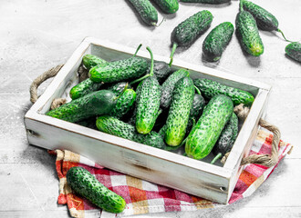 Cucumbers on a wooden tray with a napkin.