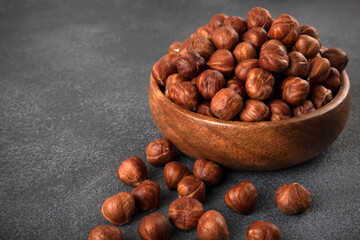 View of a bowl full of hazelnuts on a dark background