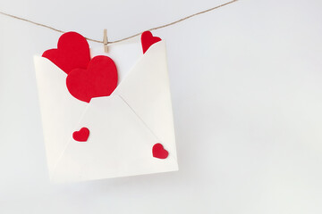 Red hearts and envelope hanging on line on wooden background. Valentines day decoration.
