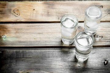 Vodka in a shot glass and ice cubes.