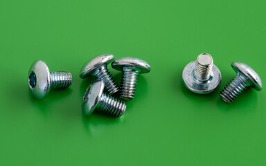 Close up of Stainless Hex socket screws on green background
