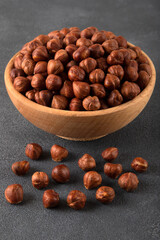 View of a bowl full of hazelnuts on a dark background
