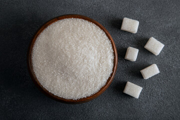 Cube sugar and granulated sugar on dark background,top view