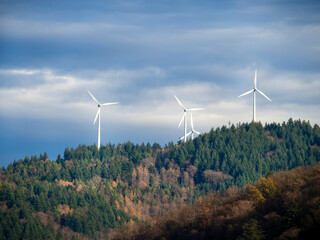 Wind turbines rotate and use the wind to make electricity on top of mountain. Large wind mills as...