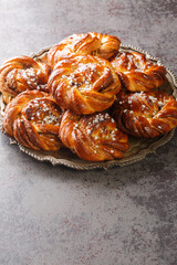 Cinnamon roll or kanelbulle is a famous Swedish pastry close-up on a plate on the table. Vertical
