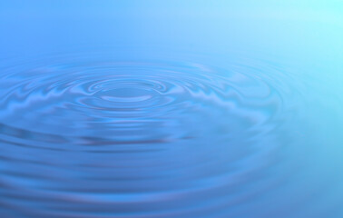 Waves of water are caused by falling droplets. close-up view.