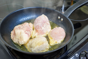 Chicken breast fillets frying in a pan