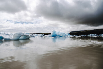 Many icebergs and ice floes in the glacial lagoon Fjalls&aacute;rl&oacute;n in iceland, which has broken away from the glacier tongue Fjallsj&ouml;kull. With a view of Hvannadalshn&uacute;kur in the background.