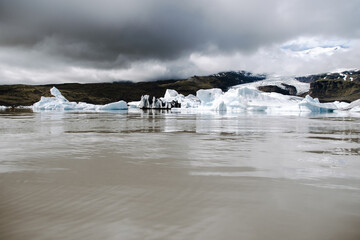 Many icebergs and ice floes in the glacial lagoon Fjalls&aacute;rl&oacute;n in iceland, which has broken away from the glacier tongue Fjallsj&ouml;kull. With a view of Hvannadalshn&uacute;kur in the background.