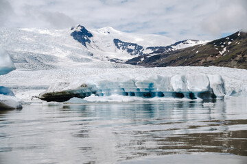 View of the glacier tongue Fjallsjökull with its icebergs and the glacier lagoon Fjallsárlón in Iceland. With a view of Öræfajökull in the background.