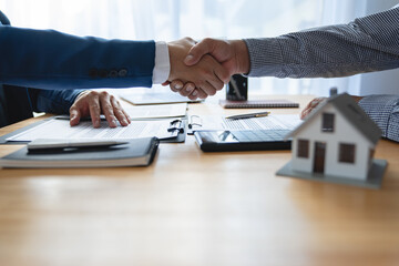 Young businessman and financial representative shaking hands after a budget deal for business expansion and investment in a village construction project real estate financial concept.