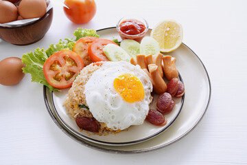 Fried rice and hot dogs, cooked fried egg, Chinese sausage and ketchup on a white background.